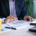 A man using a tablet and analysing financial charts